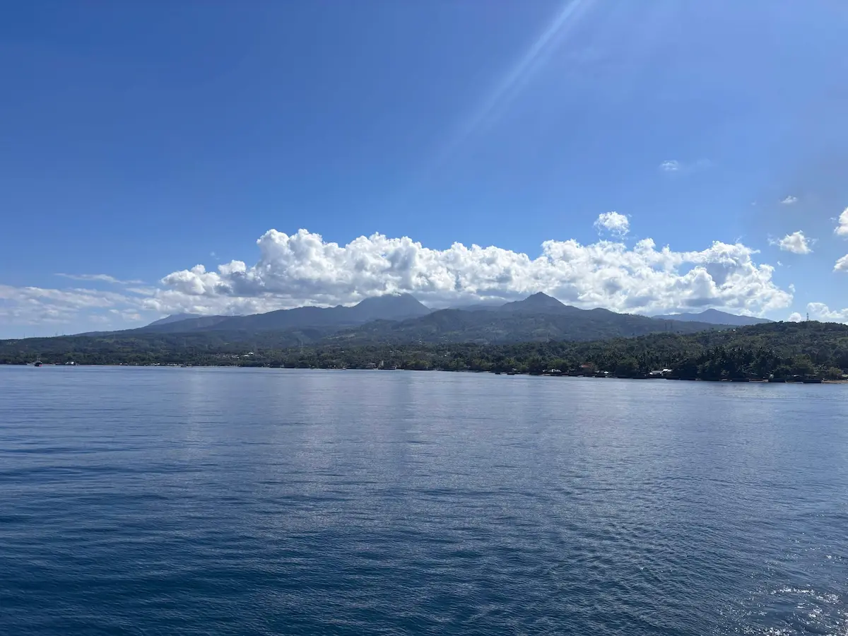 Panoramic view of Dumaguete City coastline and mountain landscape seen from the ferry to Cebu, Philippines